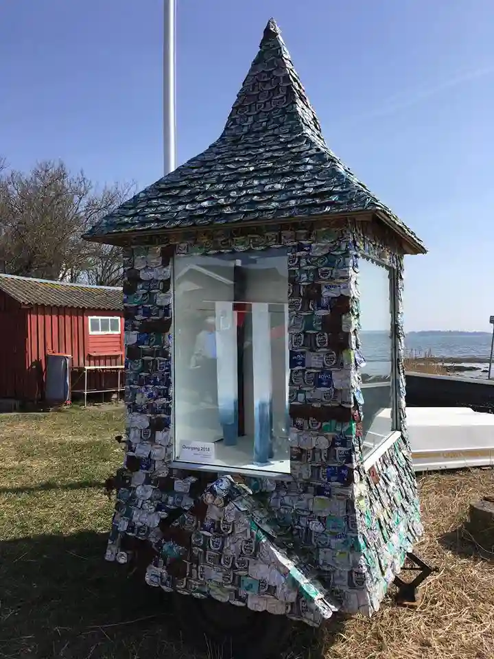 Nærbillede af en grøn sodavandsdåse lavet af små perler på en udstillingsbord.